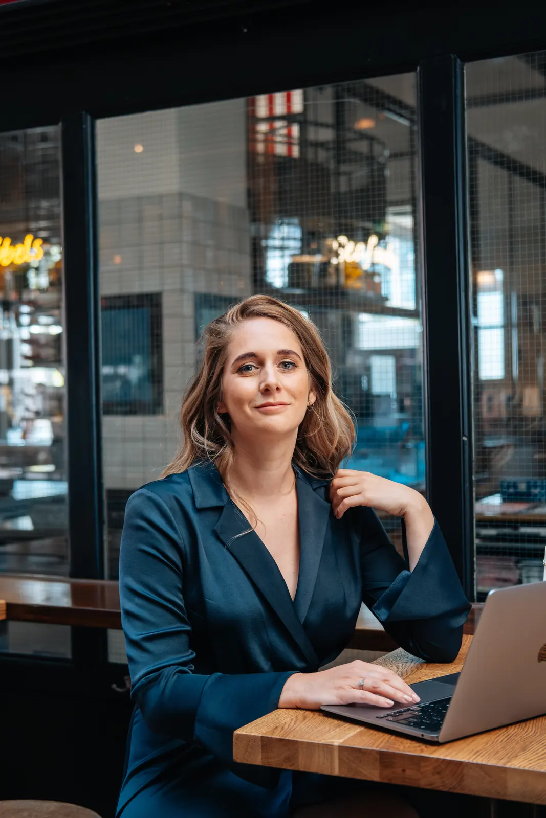 Carlijn Bekker, social media strateeg, aan de laptop in een café