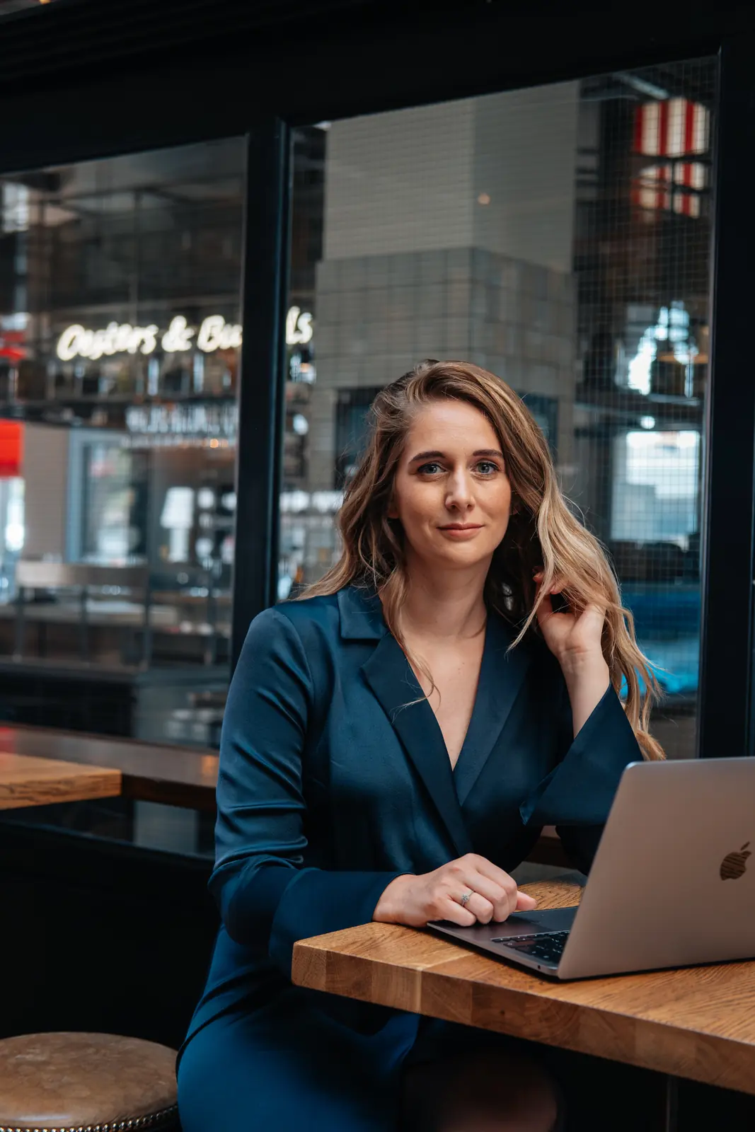 Carlijn Bekker, social media strateeg, aan de laptop in een café