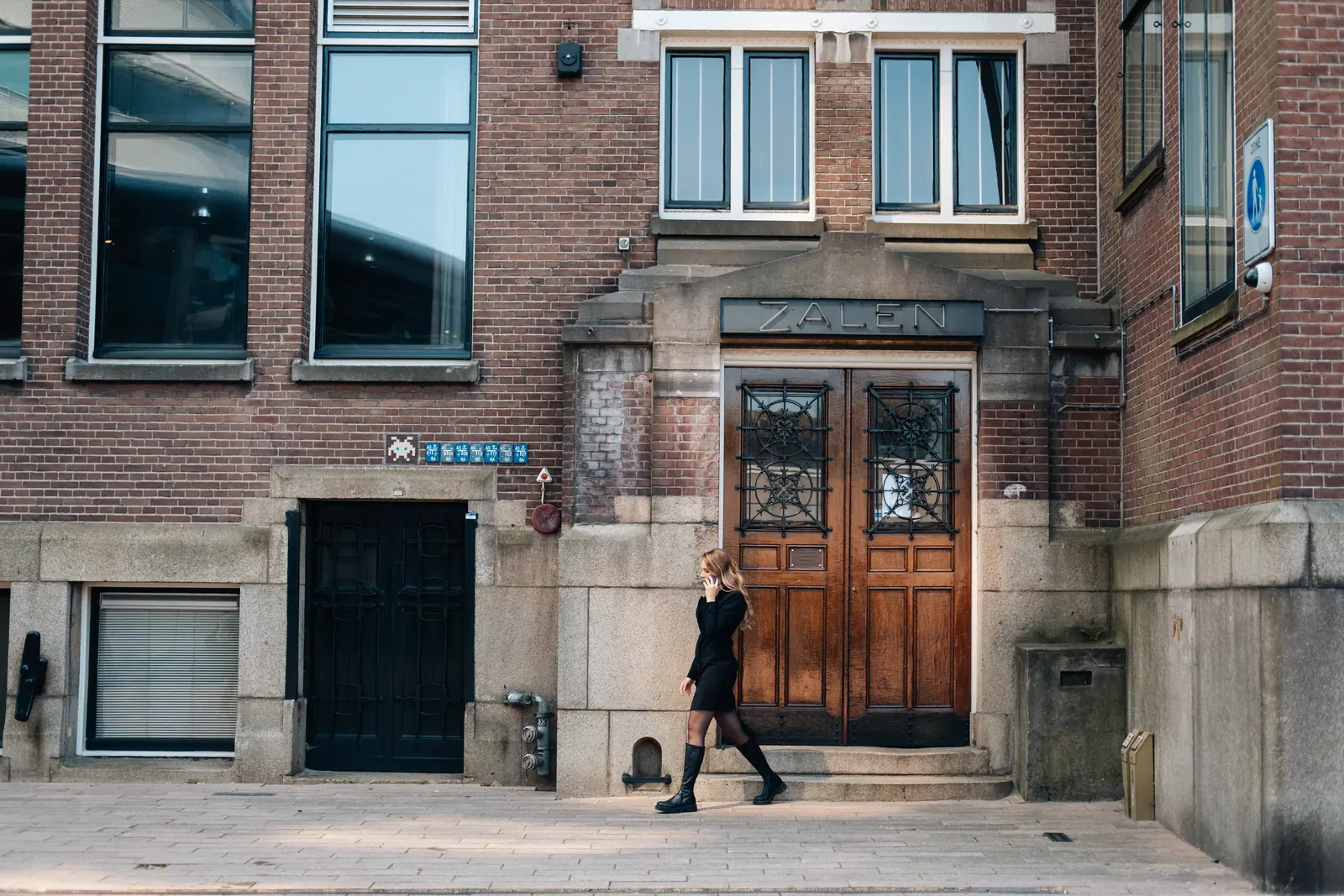 Carlijn Bekker, social media strateeg, lopend langs een oude gevel