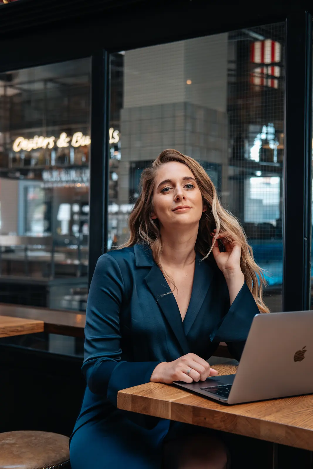 Carlijn Bekker, social media strateeg, aan de laptop in een café