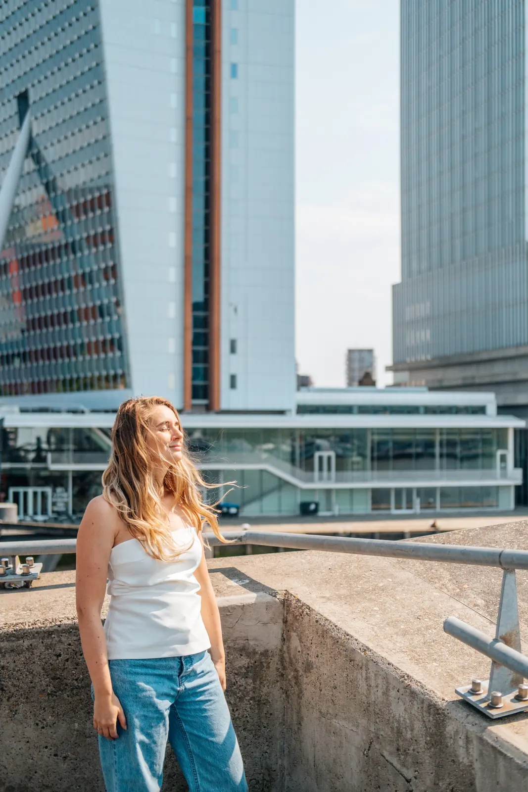 Carlijn Bekker, social media strateeg, aan het water met de Rotterdamse skyline
