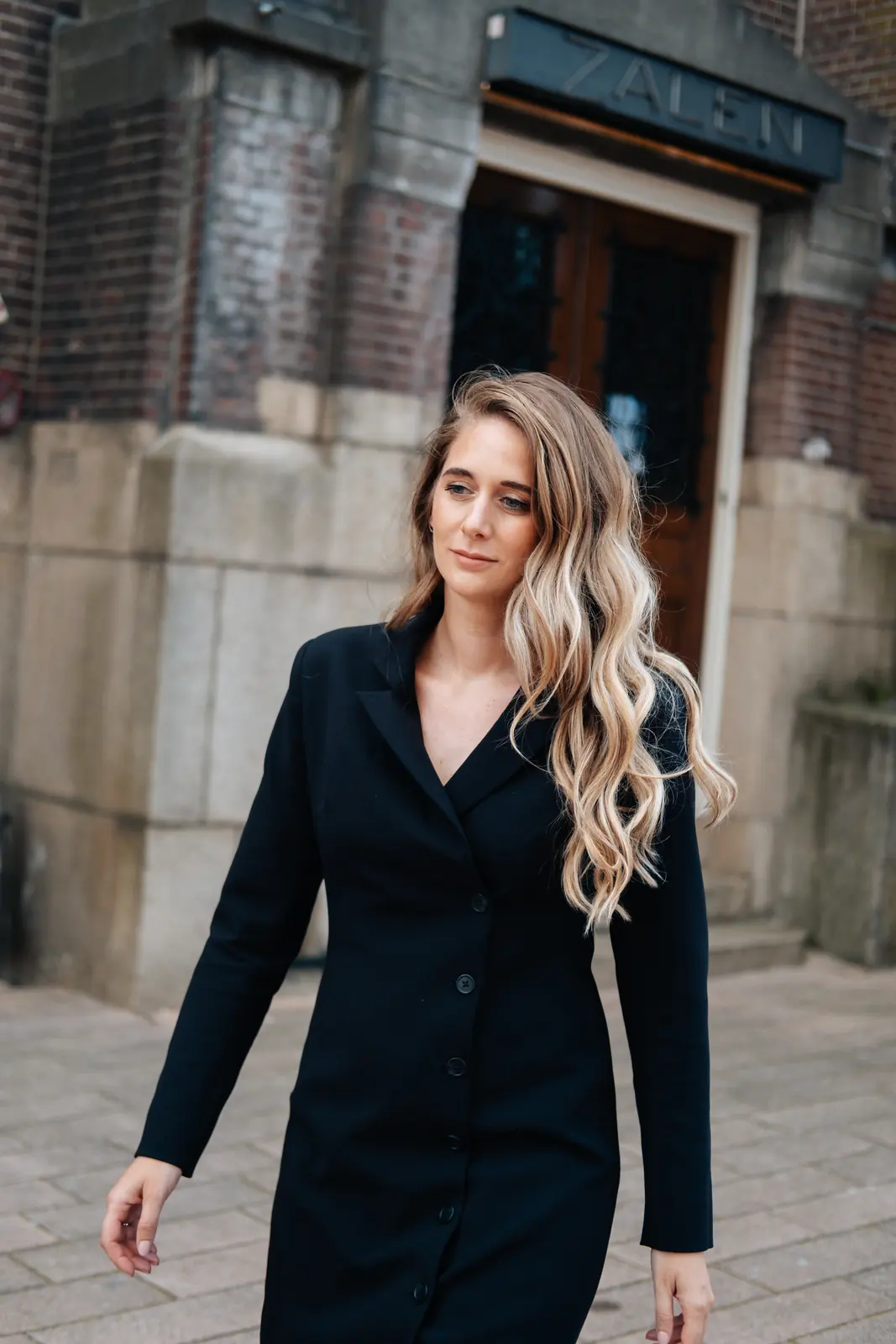 Carlijn Bekker, social media strateeg, lopend in een zwarte jurk