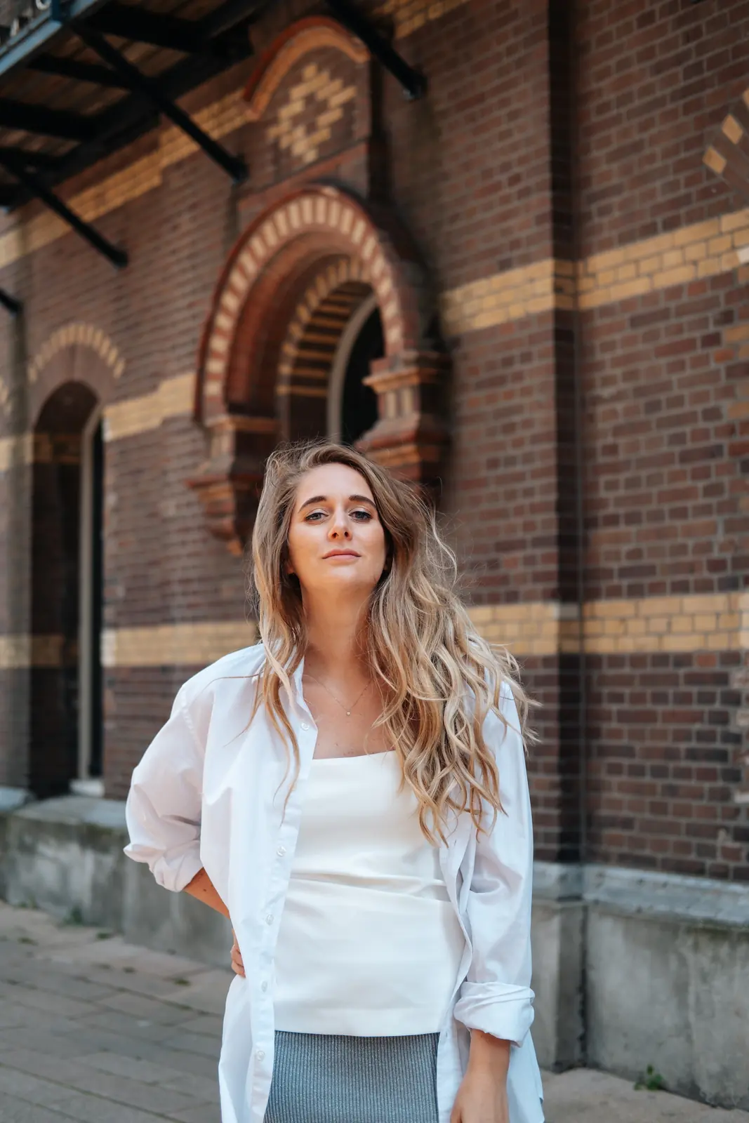Carlijn Bekker, social media strateeg, in een wit overhemd in de stad